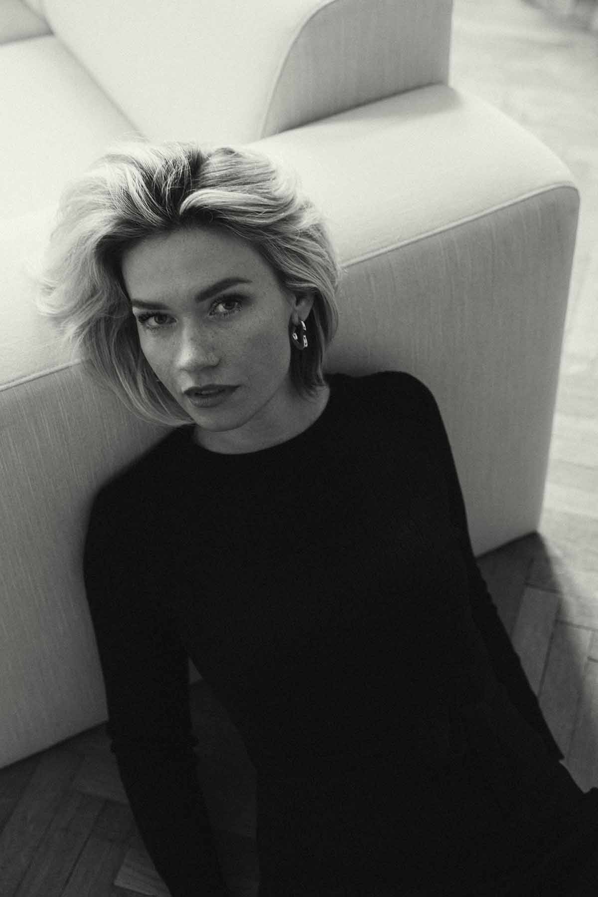 Blonde Fotografin, Shira Rachel angelehnt auf dem Sofa als schwarz weiß Fotografie.