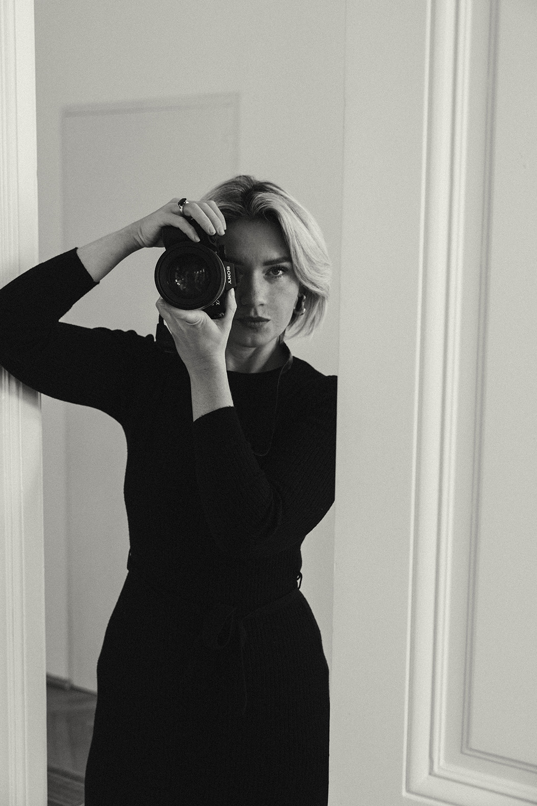Schwarz-weiß Selbstportrait einer Fotografin mit Kamera – ein persönlicher Einblick in die Arbeit von Fotografin aus Wien.