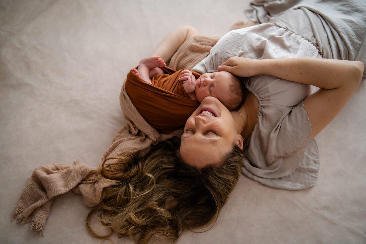 Mutter kuschelt mit Neugeborenem – inniges Babyshooting in Wien mit natürlicher Wärme und Geborgenheit.