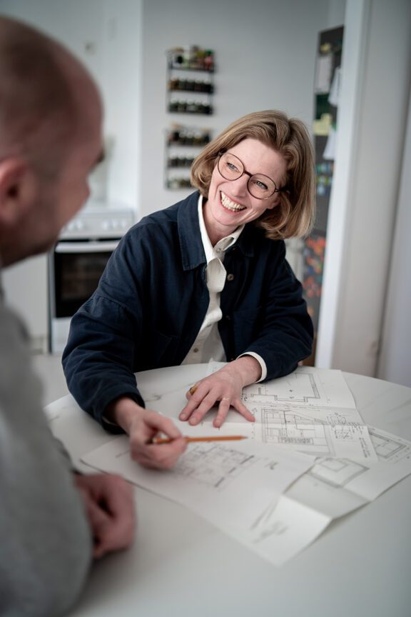 Authentische Mitarbeiterfotos in Wien zeigen eine Frau im Gespräch bei der gemeinsamen Planung am Tisch