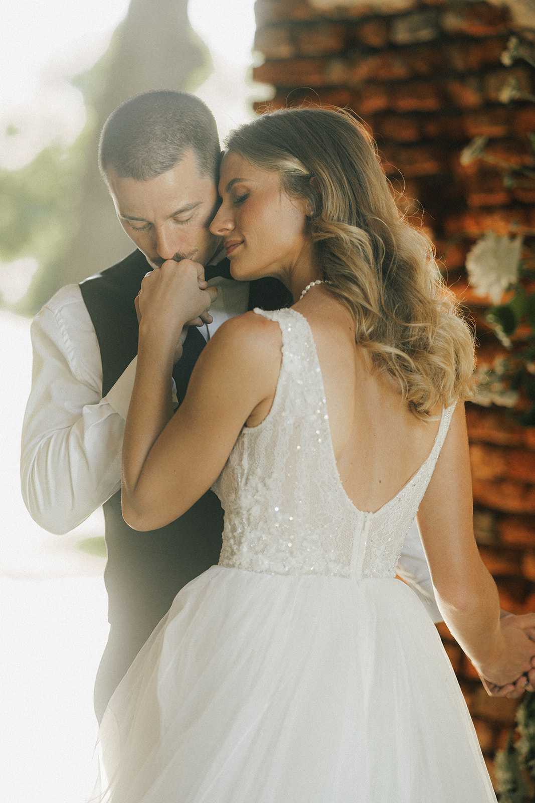 Bräutigam küsst die Hand der Braut – romantische, natürliche Hochzeitsfotografie in Wien.
