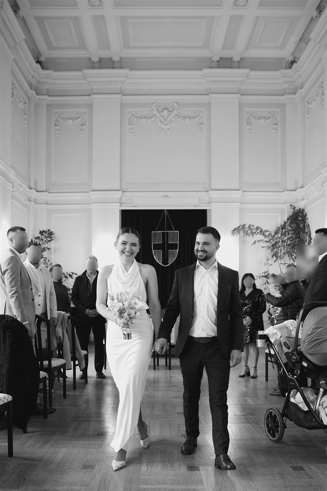 Braut und Bräutigam gehen lächelnd durch den Saal bei ihrer standesamtlichen Hochzeit in Wien – natürliche Hochzeitsreportage Wien.